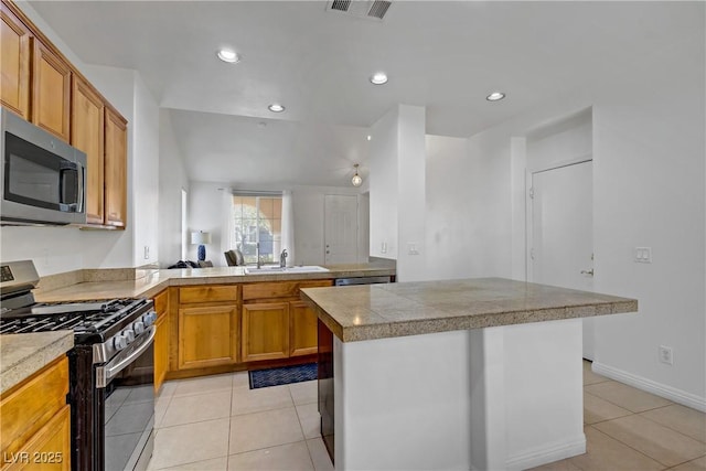2851 Glistening Grove Ave, Henderson, NV 89052 - kitchen with appliances with stainless steel finishes, light tile patterned floors, brown cabinetry, a sink, and recessed lighting