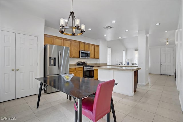 2851 Glistening Grove Ave, Henderson, NV 89052 - kitchen with stainless steel appliances, a chandelier, light tile patterned flooring, light countertops, and recessed lighting
