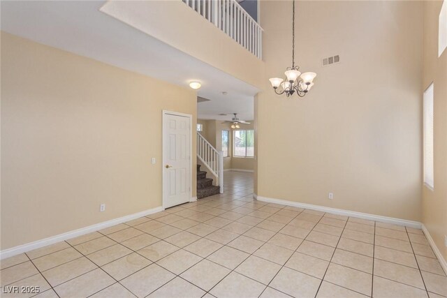 3037 Austin Pale Ave, North Las Vegas, NV 89081 - empty room with a chandelier, light tile patterned flooring, ceiling fan, baseboards, and a towering ceiling