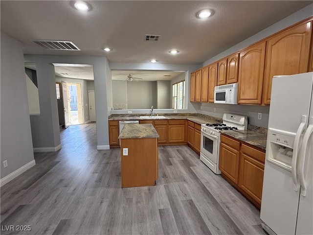 258 Bella Matese Ave, Las Vegas, NV 89183 - kitchen with white appliances, a sink, light wood-type flooring, brown cabinets, and recessed lighting