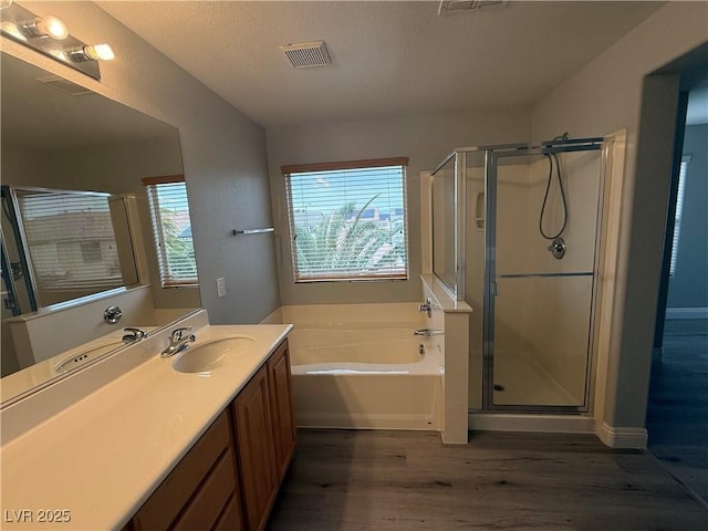 258 Bella Matese Ave, Las Vegas, NV 89183 - full bath with wood finished floors, a garden tub, vanity, a stall shower, and a textured ceiling