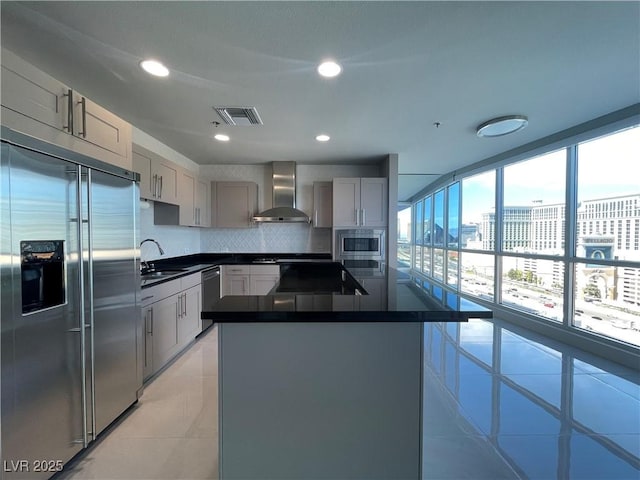 4525 Dean Martin Dr Unit 1507, Las Vegas, NV 89103 - kitchen featuring built in appliances, wall chimney exhaust hood, dark countertops, gray cabinetry, and decorative backsplash