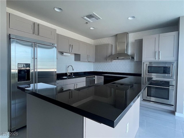4525 Dean Martin Dr Unit 1507, Las Vegas, NV 89103 - kitchen featuring wall chimney range hood, built in appliances, dark countertops, gray cabinetry, and a center island