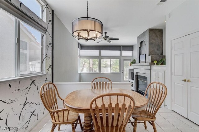 9220 Evergreen Canyon Dr, Las Vegas, NV 89134 - dining area with light tile patterned floors, a ceiling fan, and a fireplace