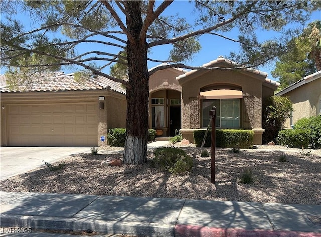 9220 Evergreen Canyon Dr, Las Vegas, NV 89134 - view of front facade featuring a tiled roof, concrete driveway, stucco siding, and an attached garage