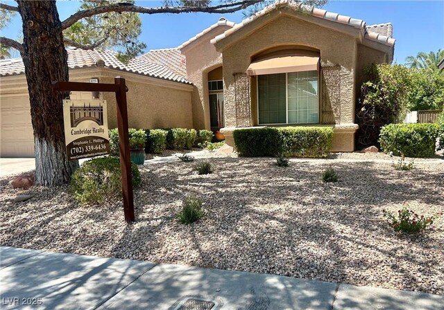 9220 Evergreen Canyon Dr, Las Vegas, NV 89134 - view of front of property featuring a tile roof, a garage, and stucco siding