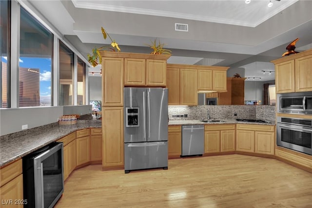 360 E Desert Inn Rd Unit 1803, Las Vegas, NV 89109 - kitchen featuring appliances with stainless steel finishes, wine cooler, light brown cabinets, light wood-type flooring, and tasteful backsplash