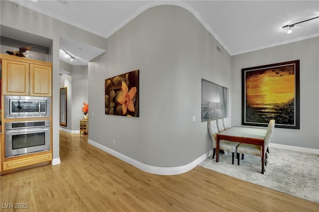 360 E Desert Inn Rd Unit 1803, Las Vegas, NV 89109 - kitchen with appliances with stainless steel finishes, light wood-style flooring, light brown cabinetry, crown molding, and baseboards
