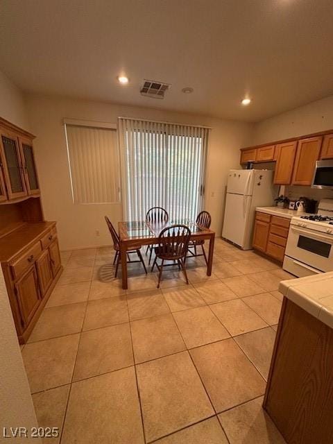3416 Mountain Park St, Las Vegas, NV 89129 - kitchen featuring white appliances, light tile patterned floors, recessed lighting, tile counters, and glass insert cabinets