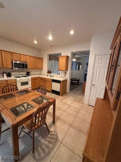 3416 Mountain Park St, Las Vegas, NV 89129 - kitchen with white gas range, stainless steel microwave, dishwashing machine, light countertops, and light tile patterned flooring