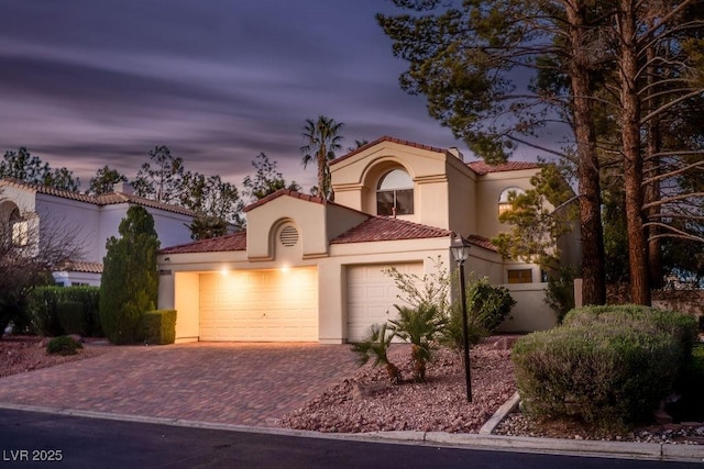 2104 Inverness Dr, Henderson, NV 89074 - mediterranean / spanish-style home with a tile roof, an attached garage, stucco siding, and decorative driveway