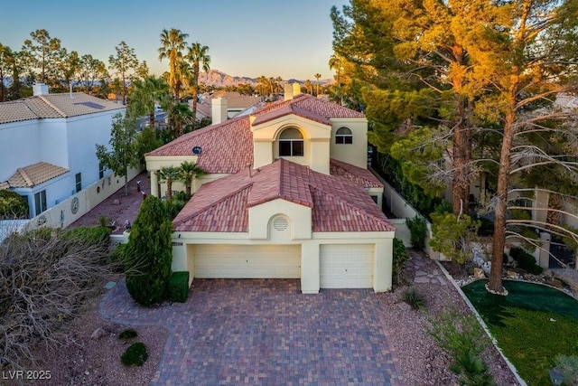2104 Inverness Dr, Henderson, NV 89074 - mediterranean / spanish-style house featuring stucco siding, driveway, an attached garage, and a tile roof