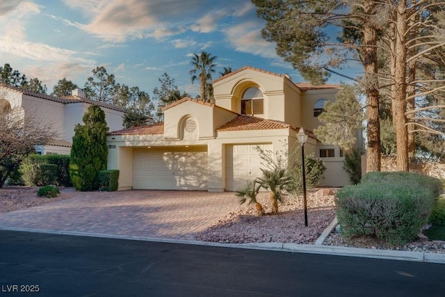 2104 Inverness Dr, Henderson, NV 89074 - mediterranean / spanish house featuring stucco siding, a tile roof, an attached garage, and driveway