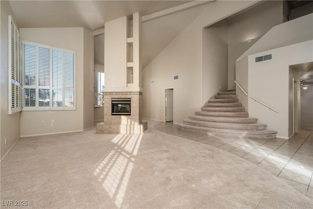 2104 Inverness Dr, Henderson, NV 89074 - unfurnished living room with a premium fireplace, light colored carpet, stairway, and high vaulted ceiling