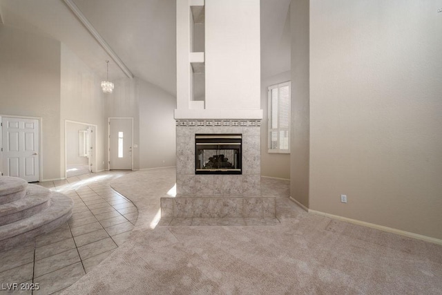 2104 Inverness Dr, Henderson, NV 89074 - unfurnished living room featuring high vaulted ceiling, carpet floors, a tiled fireplace, and tile patterned flooring