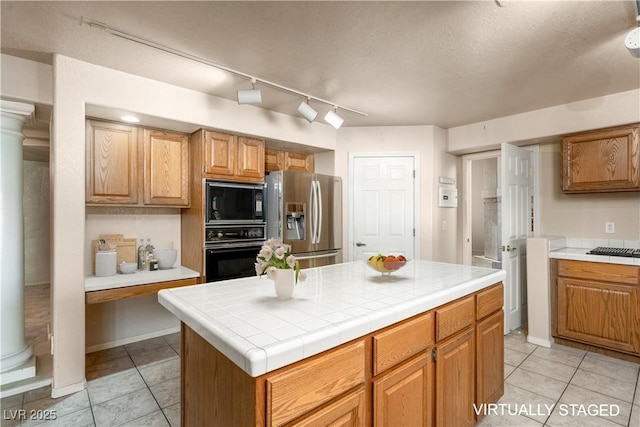 2104 Inverness Dr, Henderson, NV 89074 - kitchen with black appliances, track lighting, light tile patterned floors, and a center island