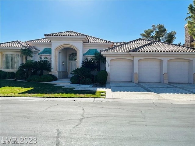 2017 Eagle Trace Way, Las Vegas, NV 89117 - mediterranean / spanish-style home featuring an attached garage, concrete driveway, stucco siding, a tile roof, and a front yard