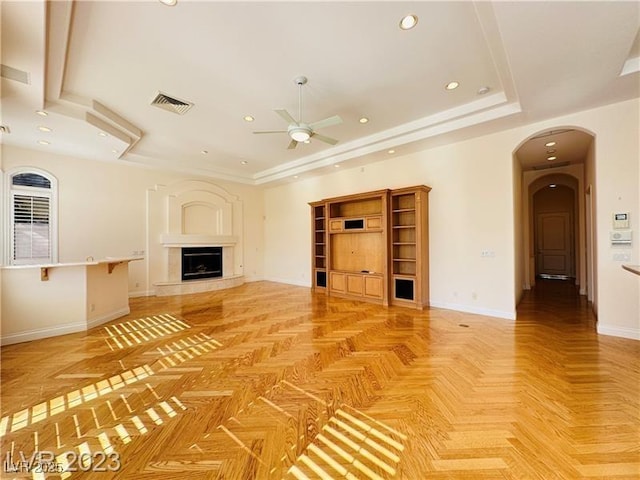 2017 Eagle Trace Way, Las Vegas, NV 89117 - unfurnished living room featuring ceiling fan, arched walkways, a tray ceiling, baseboards, and recessed lighting