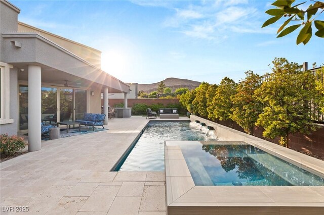 10482 Calico Terrace Ave, Las Vegas, NV 89135 - view of swimming pool featuring a mountain view, a ceiling fan, a patio area, a pool with connected hot tub, and a fenced backyard