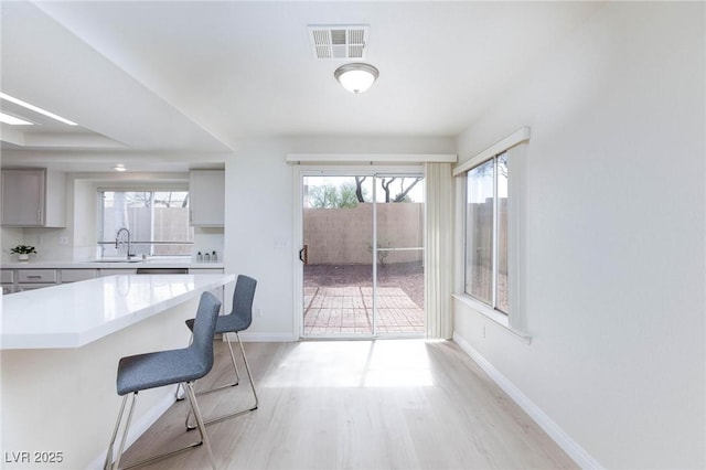 92 Sea Holly Way, Henderson, NV 89074 - kitchen featuring a breakfast bar, healthy amount of natural light, light countertops, and light wood-style floors