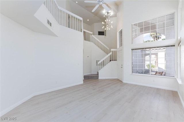 92 Sea Holly Way, Henderson, NV 89074 - unfurnished living room featuring stairway, a towering ceiling, wood finished floors, and a ceiling fan