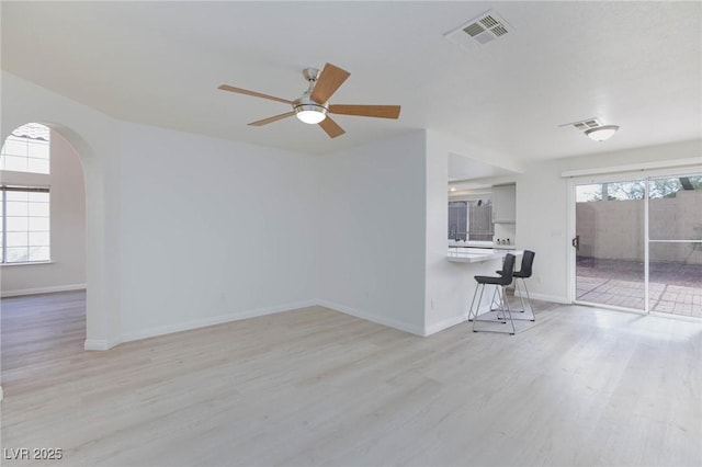 92 Sea Holly Way, Henderson, NV 89074 - unfurnished living room featuring light wood finished floors, ceiling fan, and arched walkways