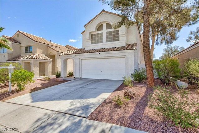 92 Sea Holly Way, Henderson, NV 89074 - mediterranean / spanish-style home with concrete driveway, stucco siding, a tiled roof, and a garage
