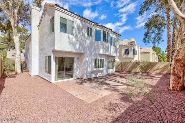 92 Sea Holly Way, Henderson, NV 89074 - rear view of house featuring stucco siding, a chimney, and a fenced backyard
