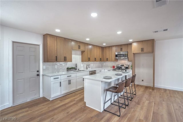 5279 Consul Ave, Las Vegas, NV 89142 - kitchen with appliances with stainless steel finishes, light wood-type flooring, tasteful backsplash, light countertops, and recessed lighting