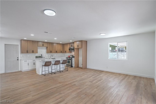 5279 Consul Ave, Las Vegas, NV 89142 - kitchen featuring stainless steel appliances, a kitchen bar, light wood-style flooring, a center island, and recessed lighting