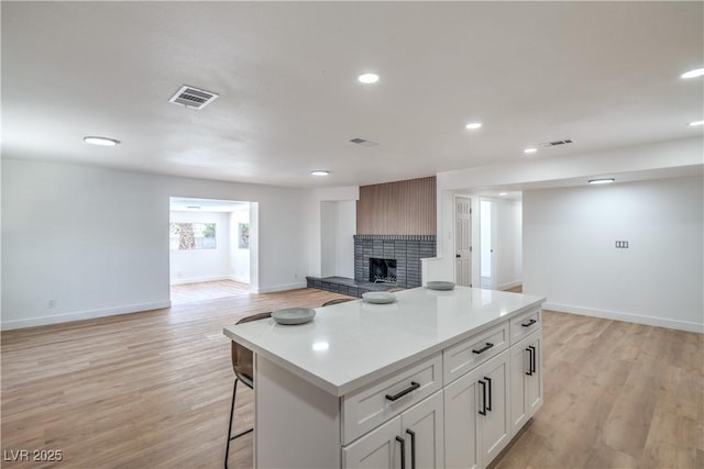 5279 Consul Ave, Las Vegas, NV 89142 - kitchen featuring open floor plan, baseboards, a fireplace, light countertops, and a kitchen island