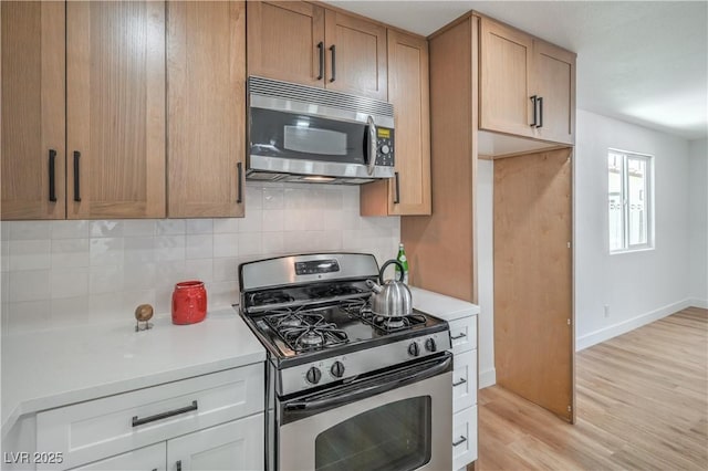 5279 Consul Ave, Las Vegas, NV 89142 - kitchen with stainless steel appliances, light countertops, decorative backsplash, and light wood-style flooring