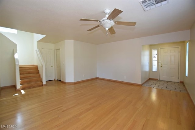 1220 Padre Serra Ln, Las Vegas, NV 89134 - unfurnished living room with light wood-style floors, baseboards, ceiling fan, and stairs