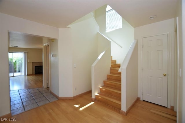 1220 Padre Serra Ln, Las Vegas, NV 89134 - staircase featuring a fireplace, wood finished floors, and baseboards