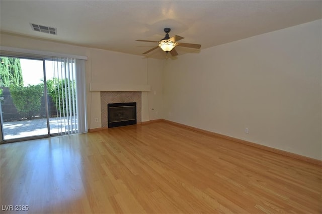 1220 Padre Serra Ln, Las Vegas, NV 89134 - unfurnished living room featuring a ceiling fan, light wood finished floors, a tile fireplace, and baseboards