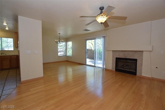 1220 Padre Serra Ln, Las Vegas, NV 89134 - unfurnished living room featuring a chandelier, light wood-style flooring, baseboards, and a fireplace