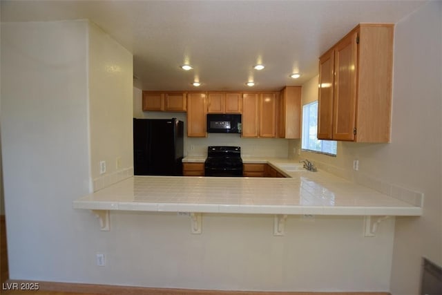 1220 Padre Serra Ln, Las Vegas, NV 89134 - kitchen with black appliances, a sink, a peninsula, recessed lighting, and tile countertops