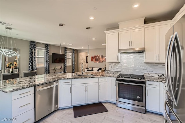 2806 Calle Cadiz, Henderson, NV 89044 - kitchen featuring appliances with stainless steel finishes, a peninsula, under cabinet range hood, white cabinets, and tasteful backsplash