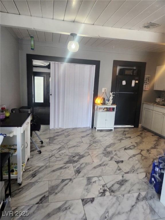 324 Princeton St, Las Vegas, NV 89107 - kitchen with black appliances, light marble finish floors, wooden ceiling with exposed beams, and dark countertops