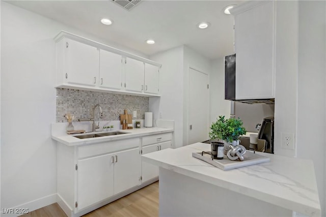 5171 Lindell Rd Unit 201, Las Vegas, NV 89118 - kitchen featuring a sink, tasteful backsplash, white cabinetry, light countertops, and recessed lighting