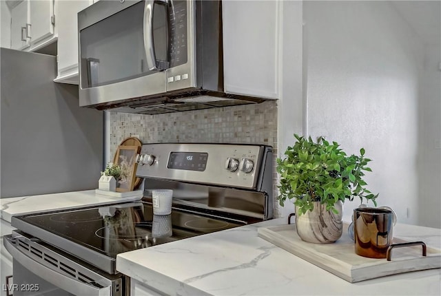 5171 Lindell Rd Unit 201, Las Vegas, NV 89118 - kitchen with appliances with stainless steel finishes, backsplash, white cabinets, and light stone countertops