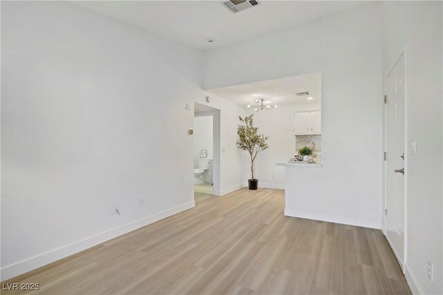 5171 Lindell Rd Unit 201, Las Vegas, NV 89118 - empty room with light wood finished floors and a chandelier
