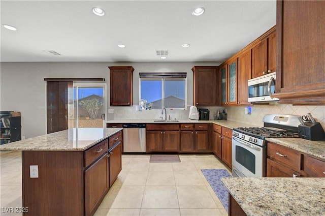 405 Prairie Moon Ave, North Las Vegas, NV 89084 - kitchen with stainless steel appliances, a sink, tasteful backsplash, light stone countertops, and light tile patterned floors