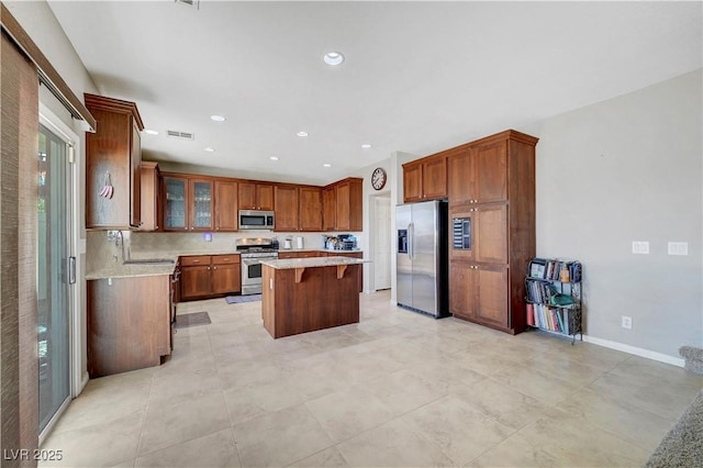 405 Prairie Moon Ave, North Las Vegas, NV 89084 - kitchen with appliances with stainless steel finishes, a kitchen island, a breakfast bar, glass insert cabinets, and a sink