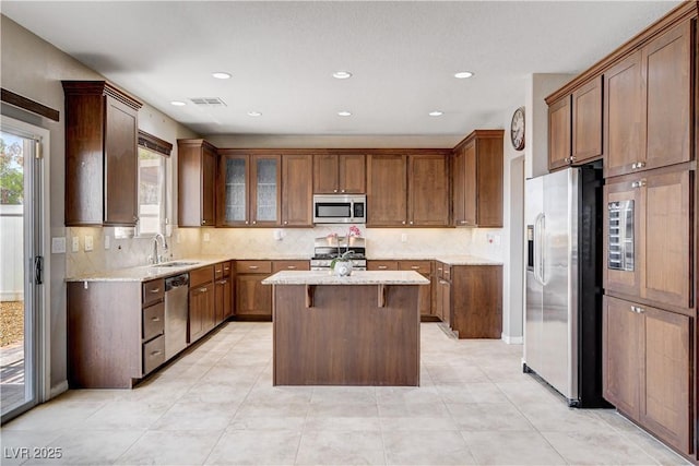 405 Prairie Moon Ave, North Las Vegas, NV 89084 - kitchen featuring stainless steel appliances, decorative backsplash, a center island, light stone counters, and recessed lighting