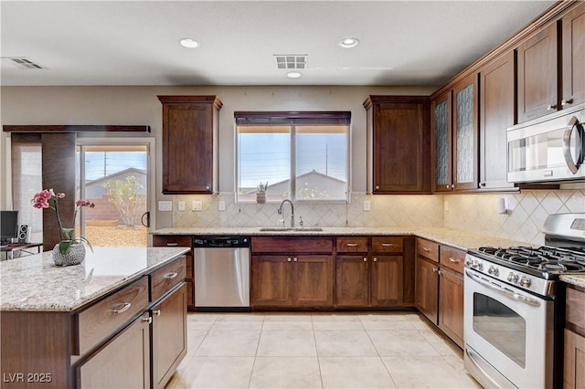 405 Prairie Moon Ave, North Las Vegas, NV 89084 - kitchen featuring appliances with stainless steel finishes, decorative backsplash, light stone counters, recessed lighting, and light tile patterned flooring