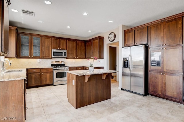405 Prairie Moon Ave, North Las Vegas, NV 89084 - kitchen with appliances with stainless steel finishes, light stone counters, backsplash, a kitchen island, and recessed lighting