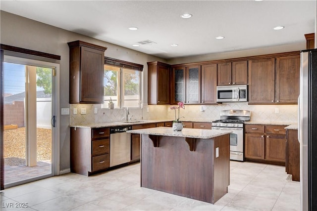 405 Prairie Moon Ave, North Las Vegas, NV 89084 - kitchen featuring stainless steel appliances, light stone counters, a kitchen island, backsplash, and recessed lighting