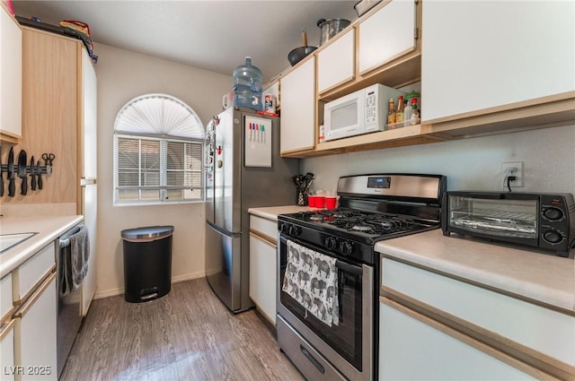 3420 Winterhaven St Unit 202, Las Vegas, NV 89108 - kitchen featuring appliances with stainless steel finishes, light wood-style floors, light countertops, white cabinetry, and baseboards