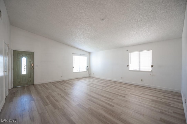 4409 Rosebank Cir, Las Vegas, NV 89108 - spare room featuring a textured ceiling, lofted ceiling, light wood-style flooring, and baseboards